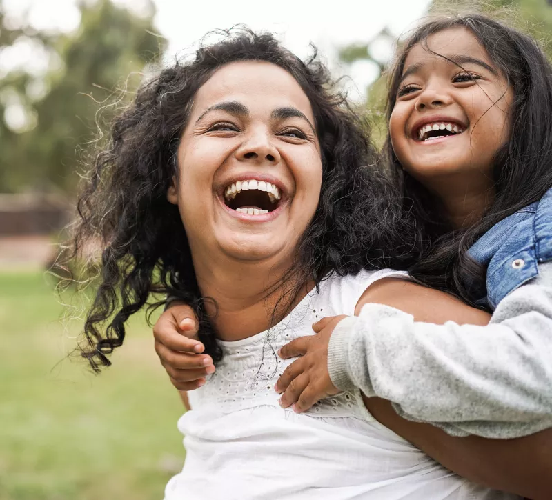 Happy mother having fun with her daughter outdoors 